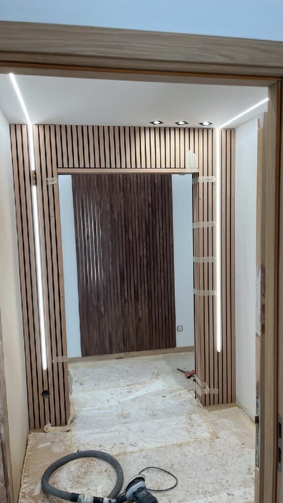 Habillage mural en tasseaux de bois en cours de pose